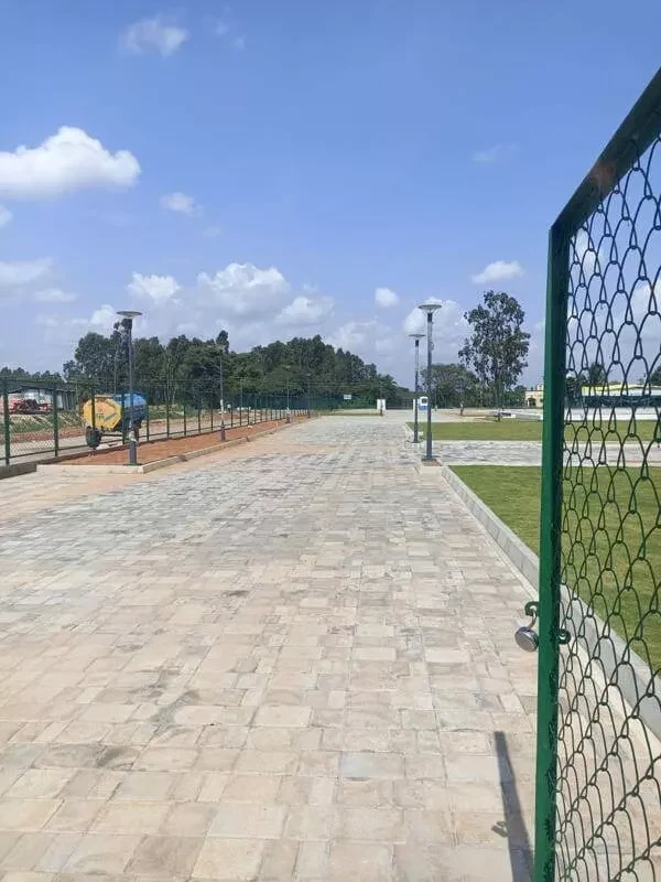 Gated entry and paved avenue at the Adarsh Springfield site, photograph